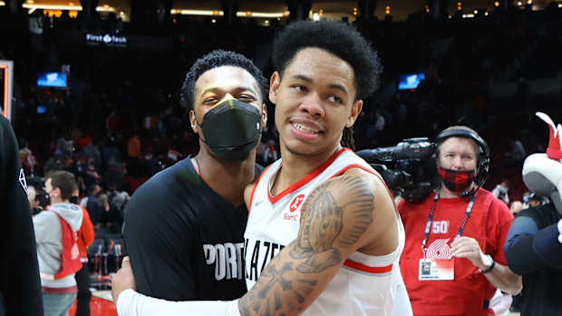 Jan 3, 2022; Portland, Oregon, USA; Portland Trail Blazers guard Anfernee Simons (1) celebrates with teammate Trail Blazers' guard Dennis Smith Jr. (10) after scoring 43 points in Portland's 136-131 win over Atlanta Hawks at Moda Center.